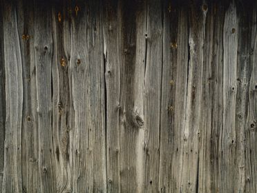Close-up of a rustic, weathered wooden fence showcasing natural textures and details.