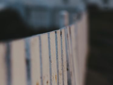 An artistic close-up of a weathered wooden fence with a focus on texture and depth.
