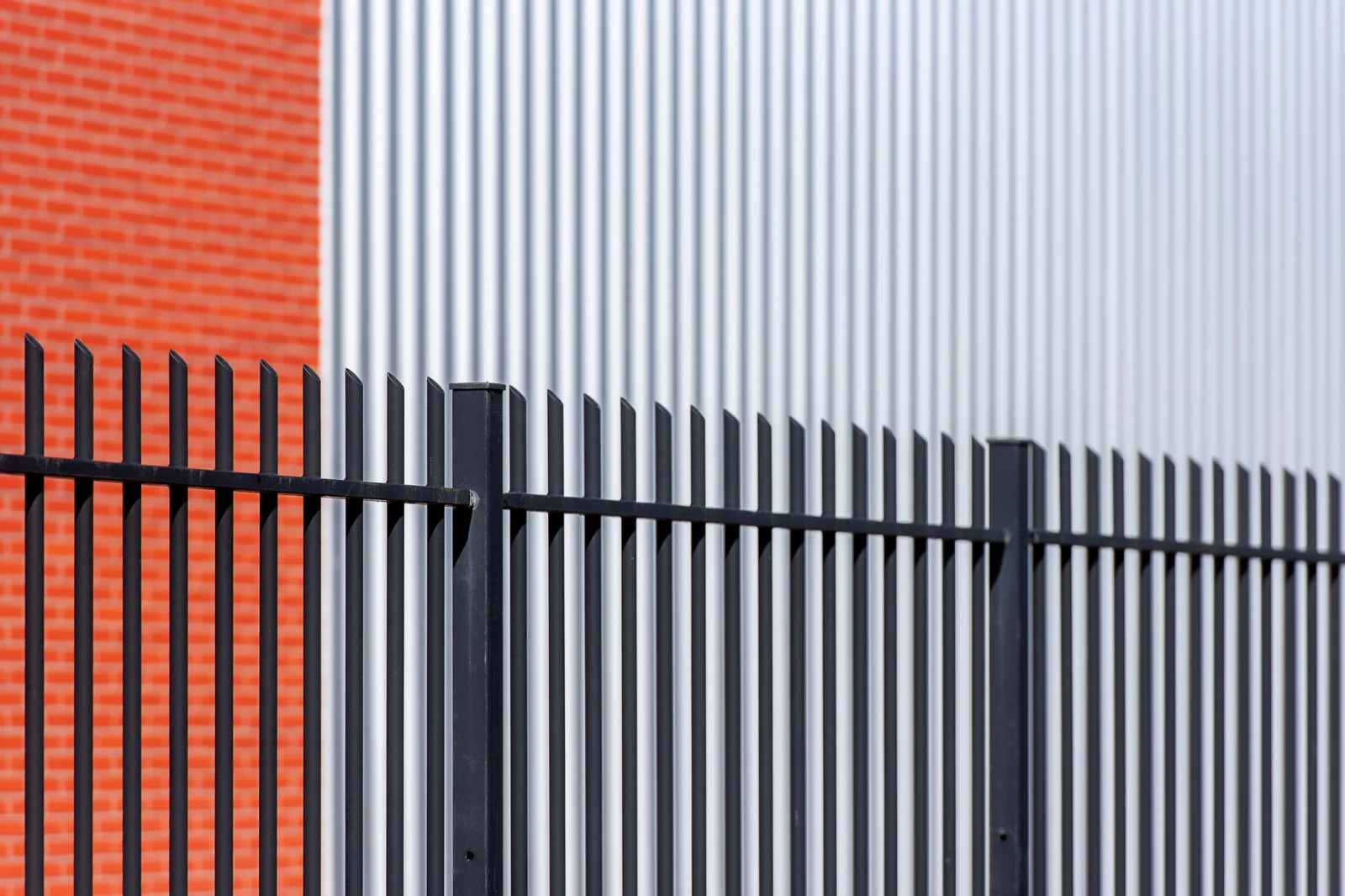 Black steel fence along a modern commercial building