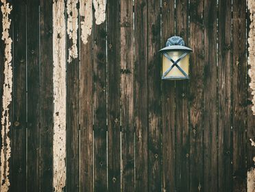 A weathered wooden fence with a vintage lantern adding rustic charm.