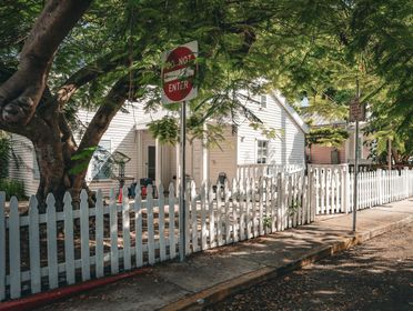 Beautiful house with a white picket fence and lush greenery in Key West, Florida.