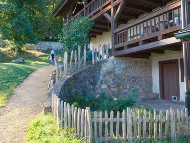 A picturesque view of a rustic house with a wooden fence and path, perfect for countryside living.